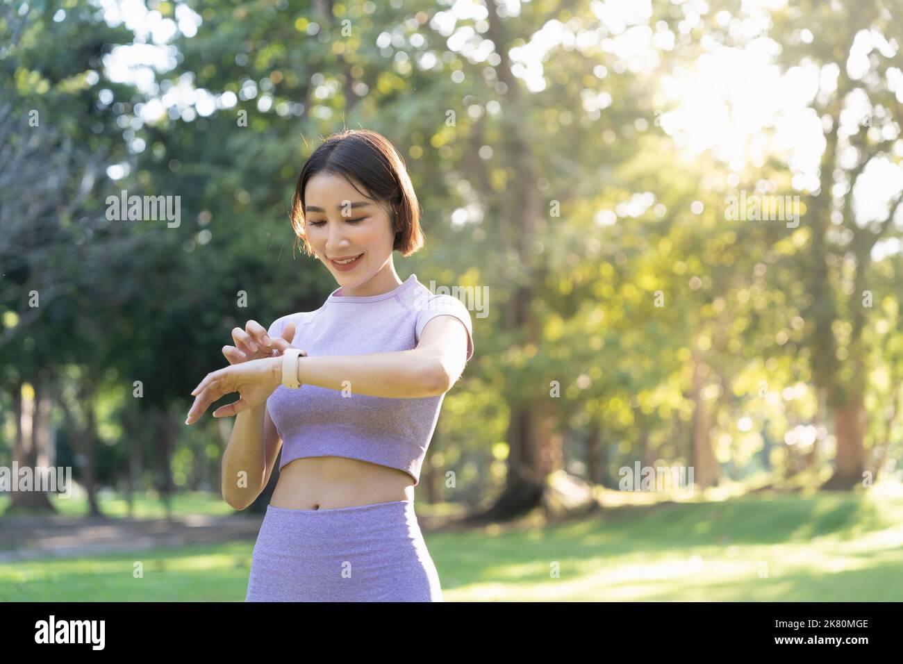 Giovane donna sportiva attiva che usa un orologio intelligente per monitorare i suoi progressi di allenamento dopo l'allenamento Foto Stock