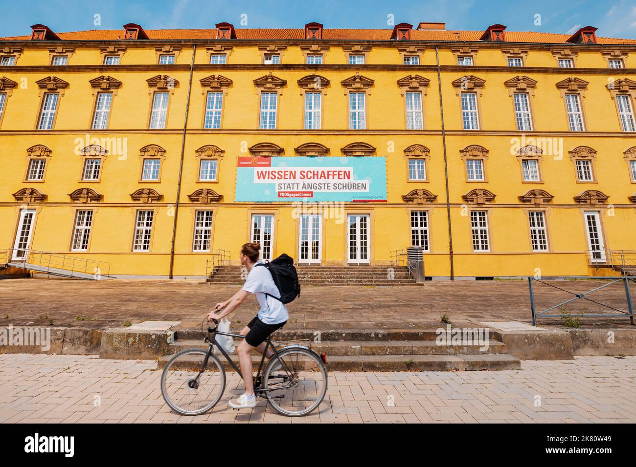 24 luglio 2022, Osnabruck, Germania: L'iscrizione sul banner presso l'università che acquisire conoscenze sul coronavirus aiuta a far fronte al Foto Stock