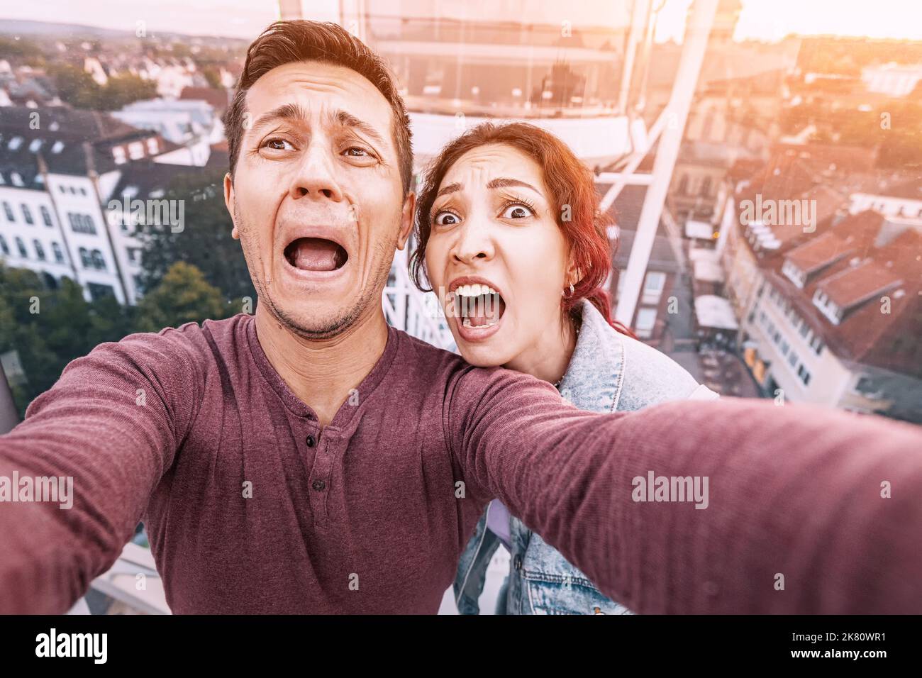 Spaventati amici maschili e femminili nella ruota panoramica sta vivendo un attacco di panico dovuto alla paura delle altezze. Il giro si è rotto e si è bloccato. Psych Foto Stock
