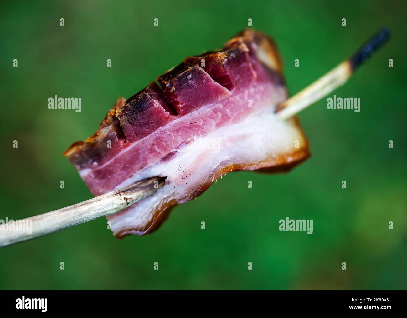 Pancetta di maiale cruda sullo spiedino all'aperto Foto Stock