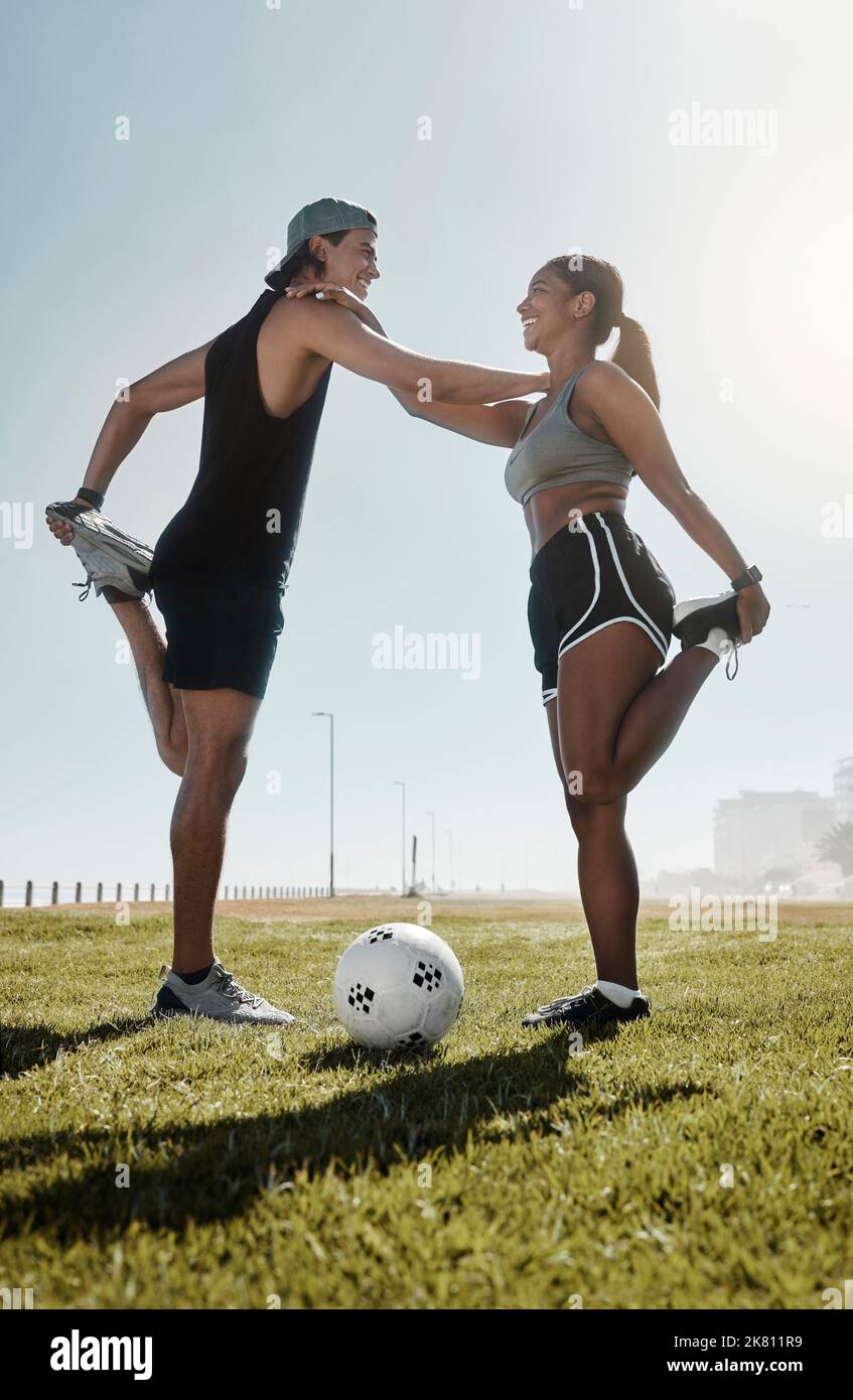 Esercizio fisico, uomo e donna che fanno calcio, stretching per il gioco ed essere sani sul campo per il benessere, allenamento e fitness insieme. Maschio, femmina e. Foto Stock