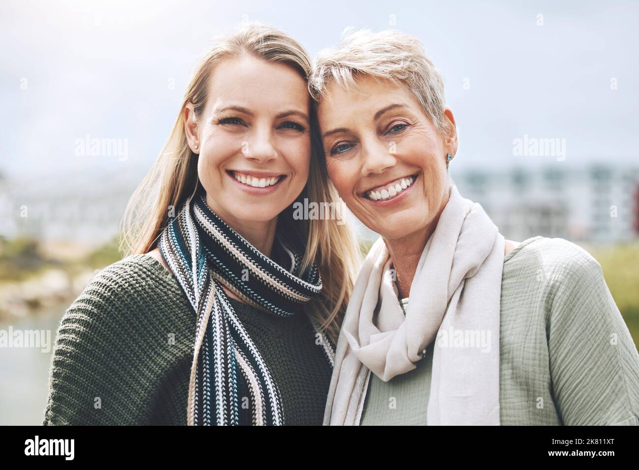 Felice, madre e figlia con sorriso nella natura insieme nella città di Australia. Ritratto facciale di una giovane donna con un anziano nella città o. Foto Stock