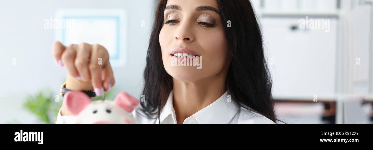 Bella donna mettere moneta in contenitore piggybank, lavoratore risparmiare denaro, raccogliere contanti Foto Stock