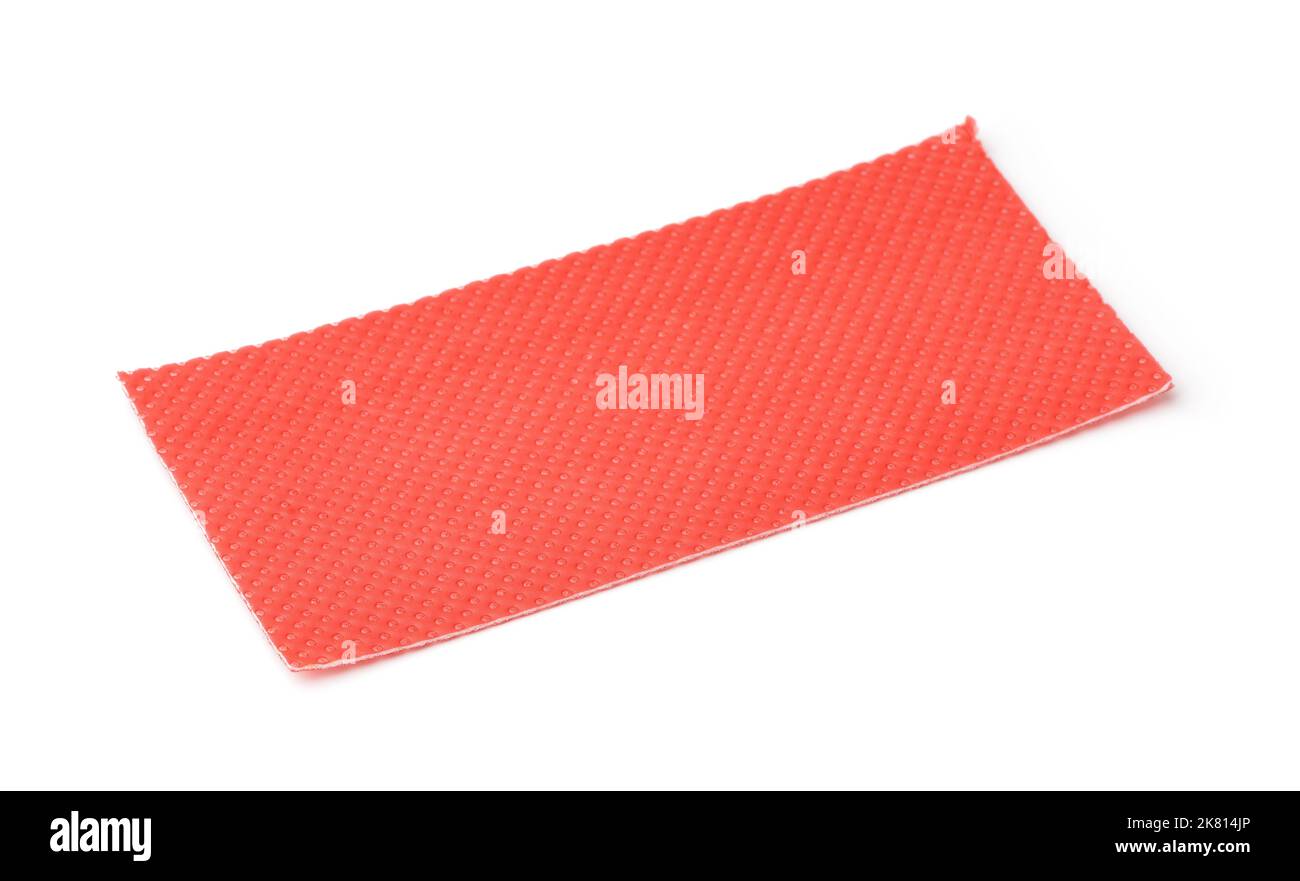 Pezzo di plastica rossa perforata sotto il rivestimento isolato su bianco Foto Stock