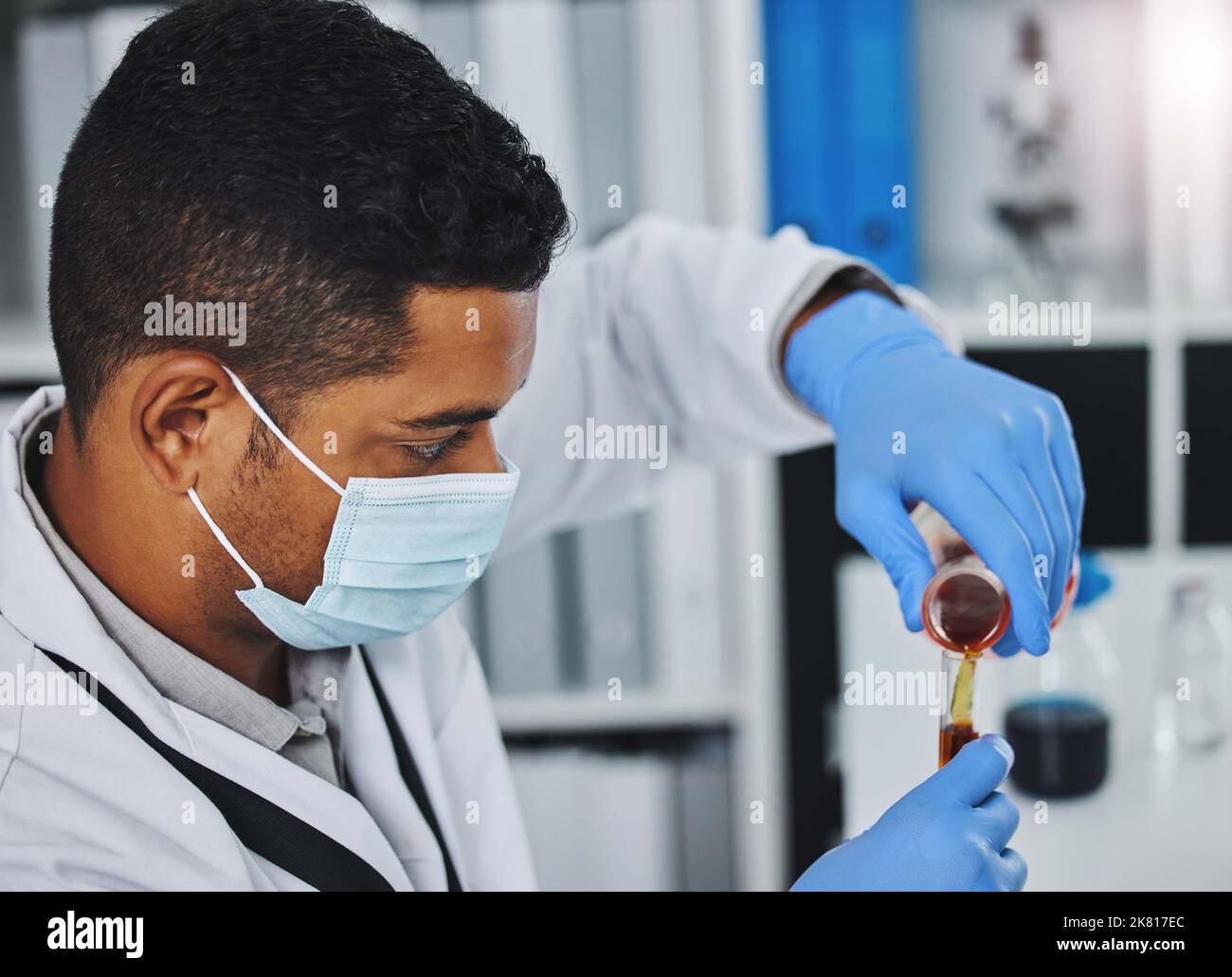 Devo essere molto preciso: Un giovane ricercatore maschile che lavora in un laboratorio. Foto Stock