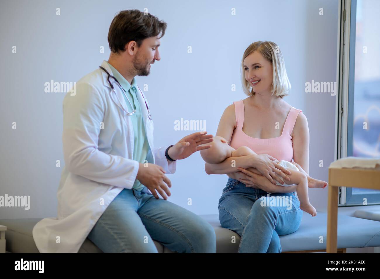 Medico pediatrico che riceve i pazienti nel suo ufficio Foto Stock