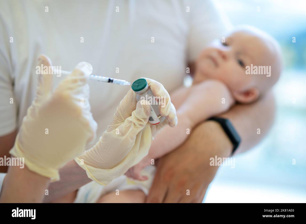 Pediatra che si prepara a vaccinare un neonato Foto Stock