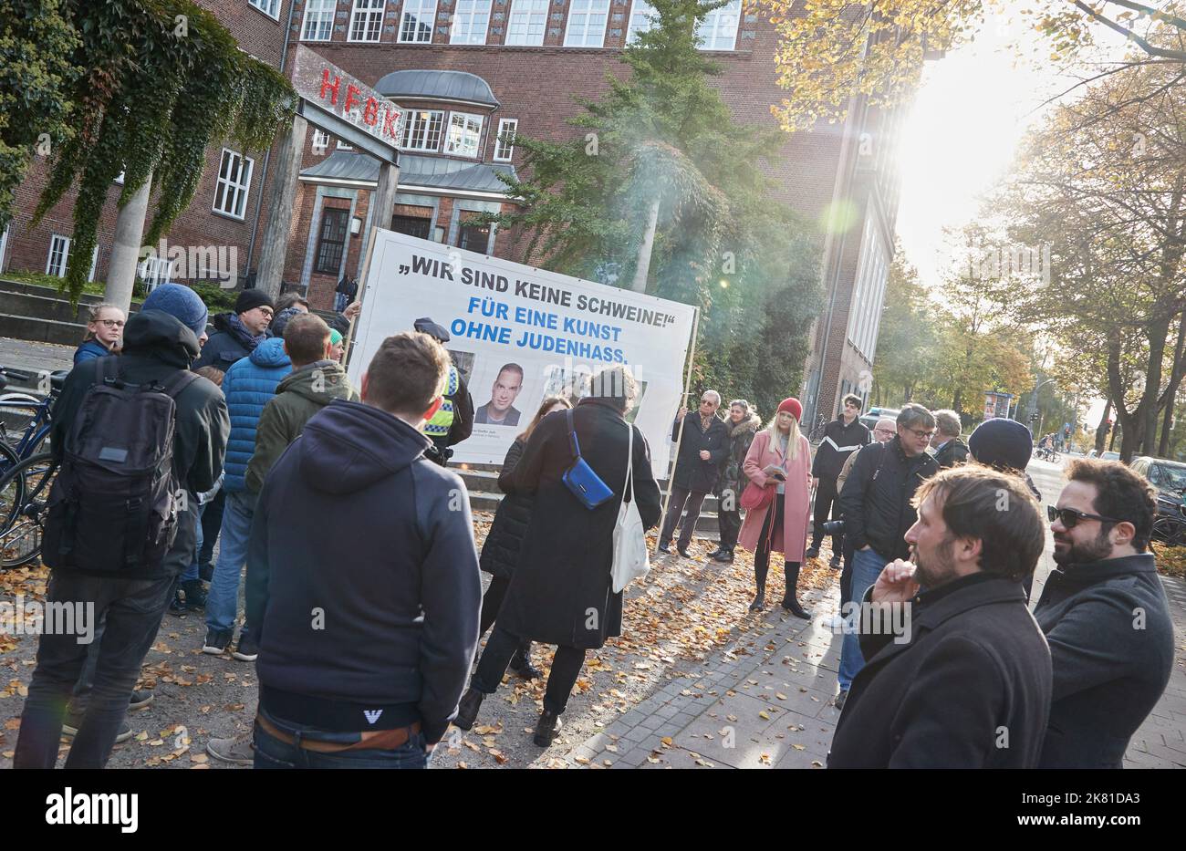 Amburgo, Germania. 20th Ott 2022. I partecipanti a una protesta degli ebrei di Amburgo contro la nomina di due professori in visita di Ruangrupa alla Scuola di Belle Arti di Amburgo (HBFK) hanno in mano una bandiera che legge ''non siamo maiali!' Per un'arte senza odio per gli ebrei.' davanti all'ingresso della scuola d'arte. I professori in visita sono membri del collettivo curatoriale indonesiano di documenta Ruangrupa. L'edizione 15th della mostra d'arte era stata messa in ombra da sempre nuove accuse di antisemitismo. Credit: Georg Wendt/dpa/Alamy Live News Foto Stock