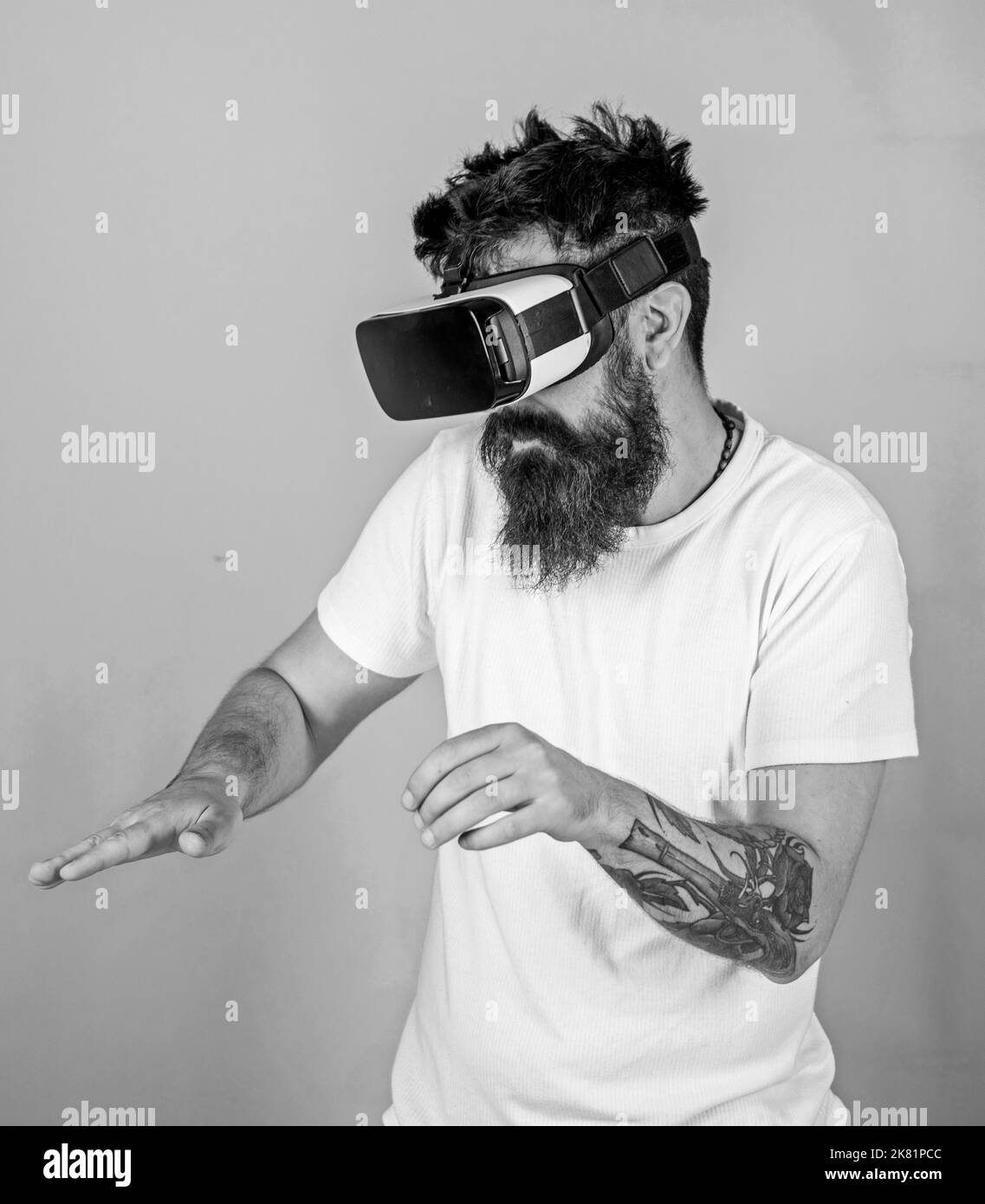 Uomo con la barba in VR occhiali, sfondo verde. Hipster sulla faccia di occupato di utilizzare le moderne tecnologie per svago o l'istruzione. VR musicista concetto. Guy Foto Stock