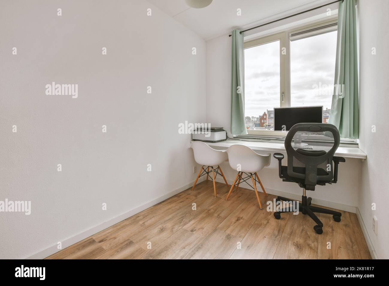 Interni minimalisti della sala studio con pavimento in parquet e pareti bianche arredate con divano e tavolo Foto Stock