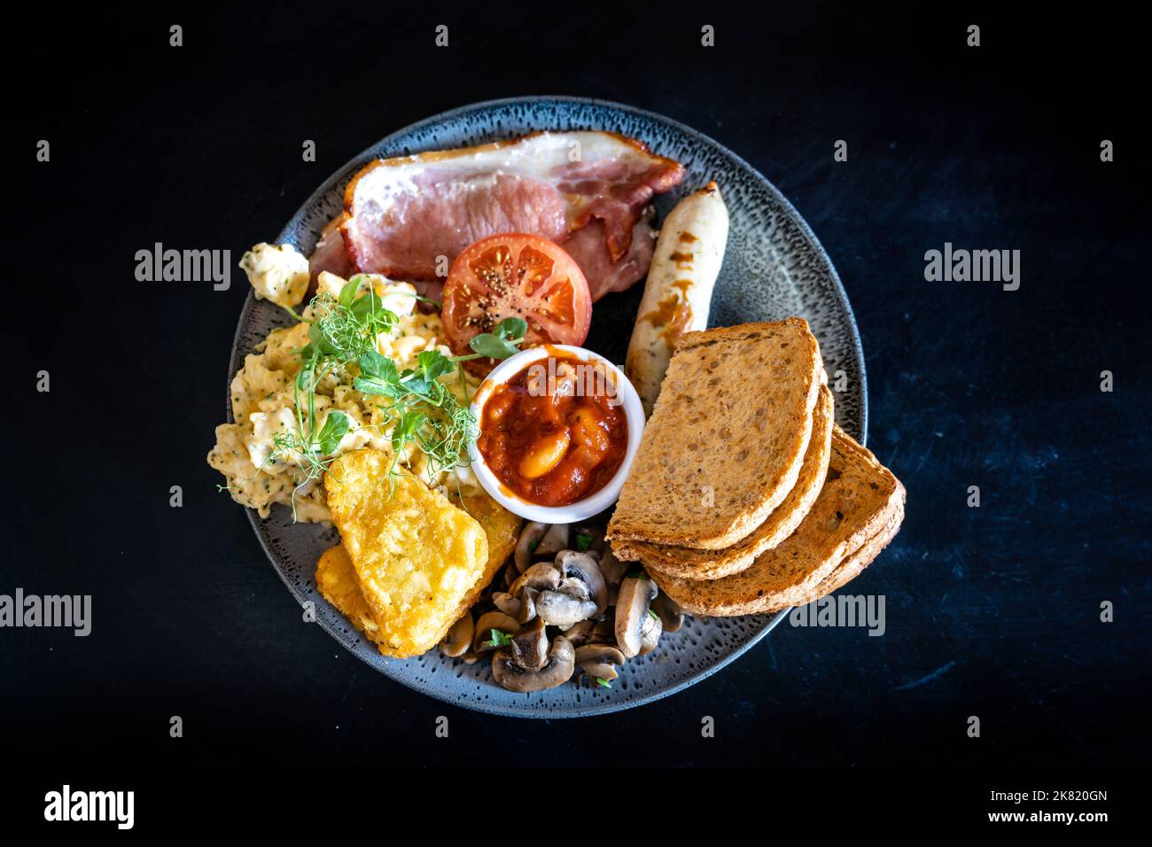 Vista dall'alto di una colazione inglese completa su un tavolo di pietra nera Foto Stock