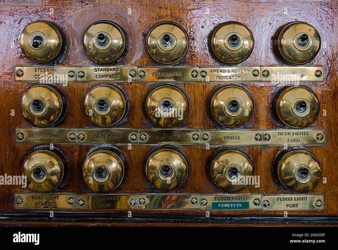 Bank of Old Brass Light Switches on Wood sul ponte della nave a vapore SS Sheildhall, Southampton, Regno Unito Foto Stock