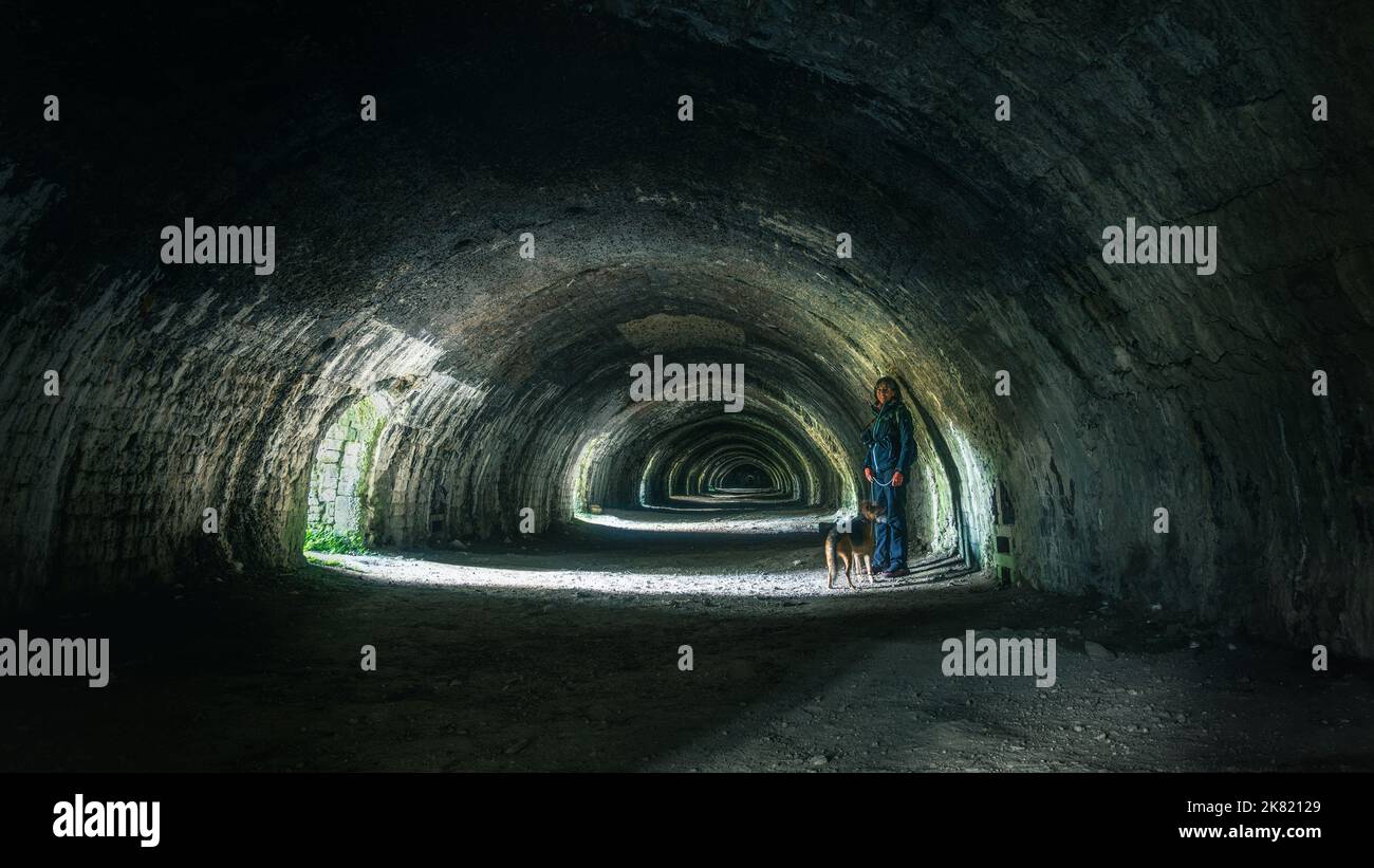 All'interno del vecchio Hoffman Lime Kiln al Craven Lime Works con una persona e un cane a Stainforth nelle Yorkshire Dales. REGNO UNITO Foto Stock
