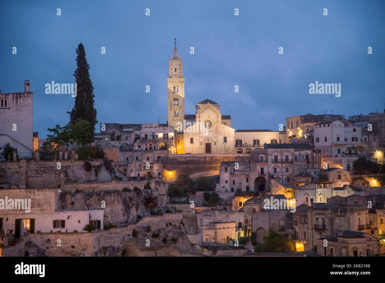 Italia, Basilicata regione: Matera. Panoramica della cattedrale e del quartiere Sasso Caveoso con le sue abitazioni troglodite di notte. La città è reg Foto Stock