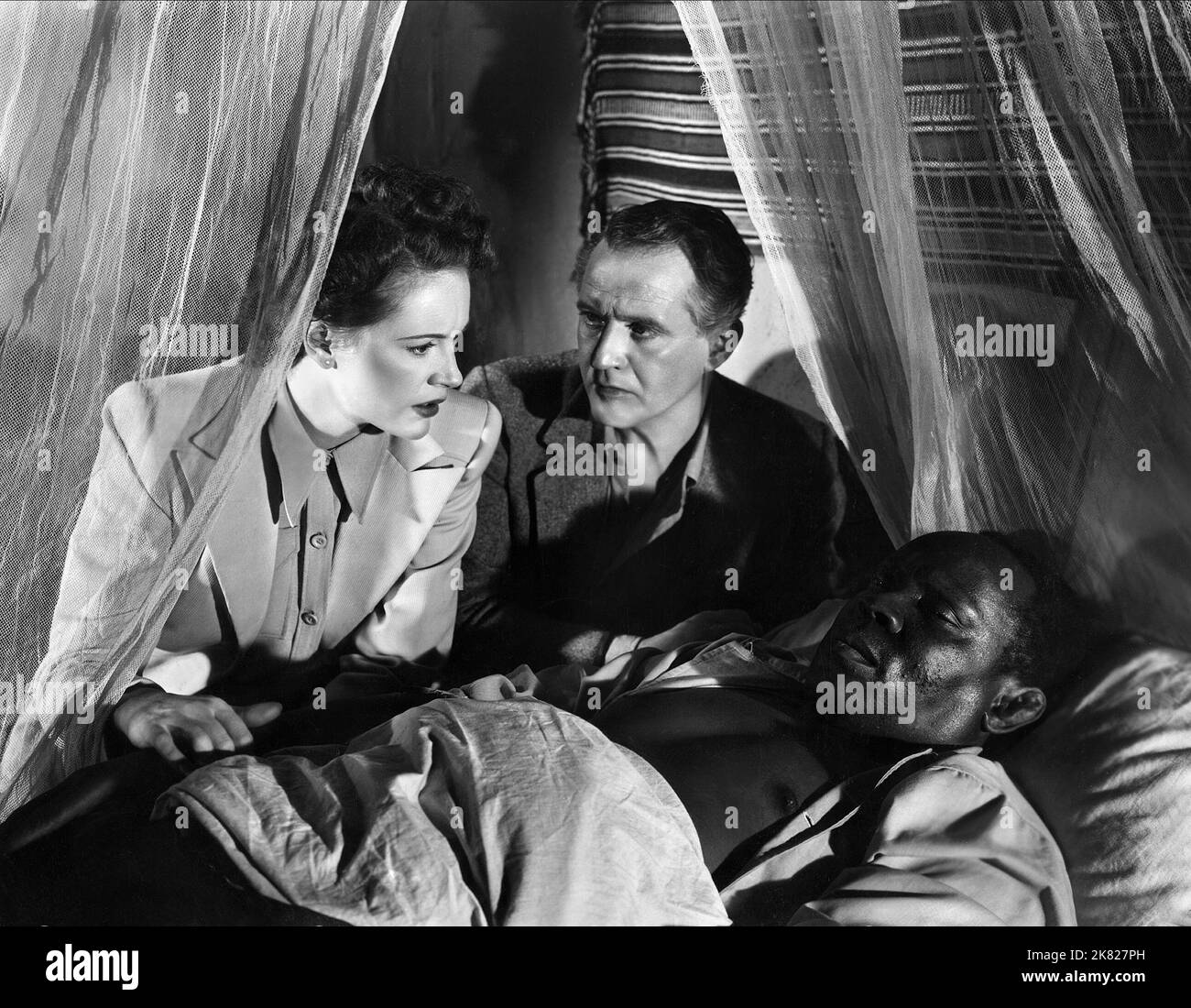 Phyllis Calvert, Eric Portman & Robert Adams Film: Men of Two Worlds (1946) personaggi: Dr. Caroline Munro, Commissario distrettuale Randall & Kisenga Direttore: Thorold Dickinson 09 settembre 1946 **AVVERTENZA** questa fotografia è solo per uso editoriale ed è copyright della GFD e/o del fotografo assegnato dalla Film o dalla Production Company e può essere riprodotta solo da pubblicazioni in concomitanza con la promozione del film di cui sopra. È richiesto un credito obbligatorio per GFD. Il fotografo deve essere accreditato anche quando è noto. Nessun uso commerciale può essere concesso senza l'autorizzazione scritta da parte di Foto Stock
