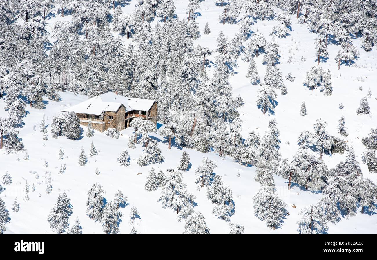 Casa di chalet solitario alle pendici di una montagna innevata in inverno. Foto Stock