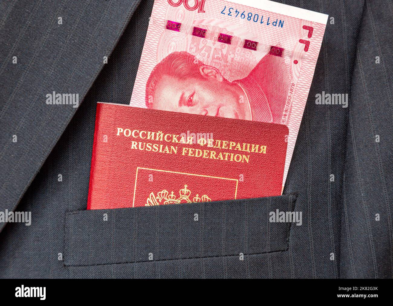 Banconote in valuta cinese e passaporto russo in tasca per tuta da lavoro Foto Stock
