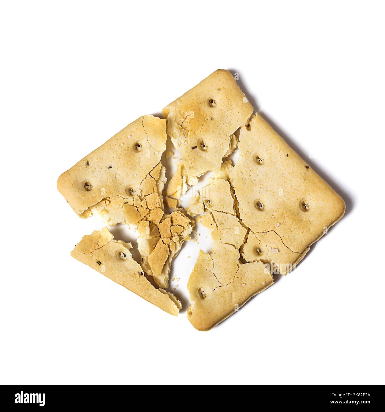 Cracker rotto isolato su sfondo bianco con ombra Foto Stock