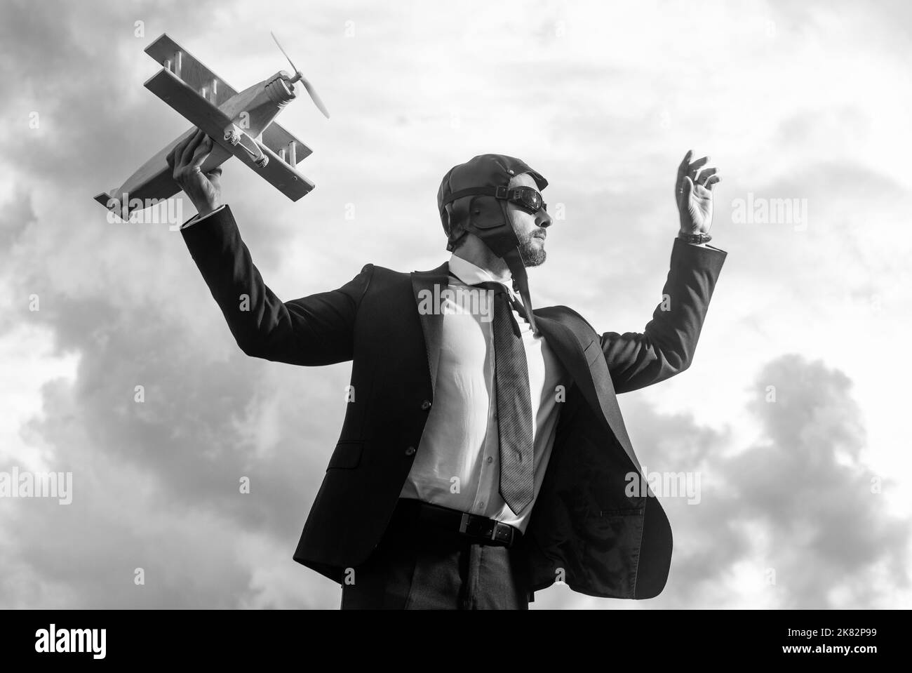 ambizioso uomo d'affari in tuta e cappello pilota lancio aereo giocattolo Foto Stock
