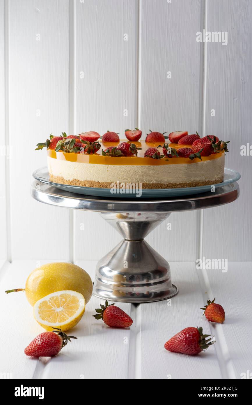 deliziosa cheesecake decorata con fragole e gelatina di frutto della passione, torta in studio, pasticceria Foto Stock