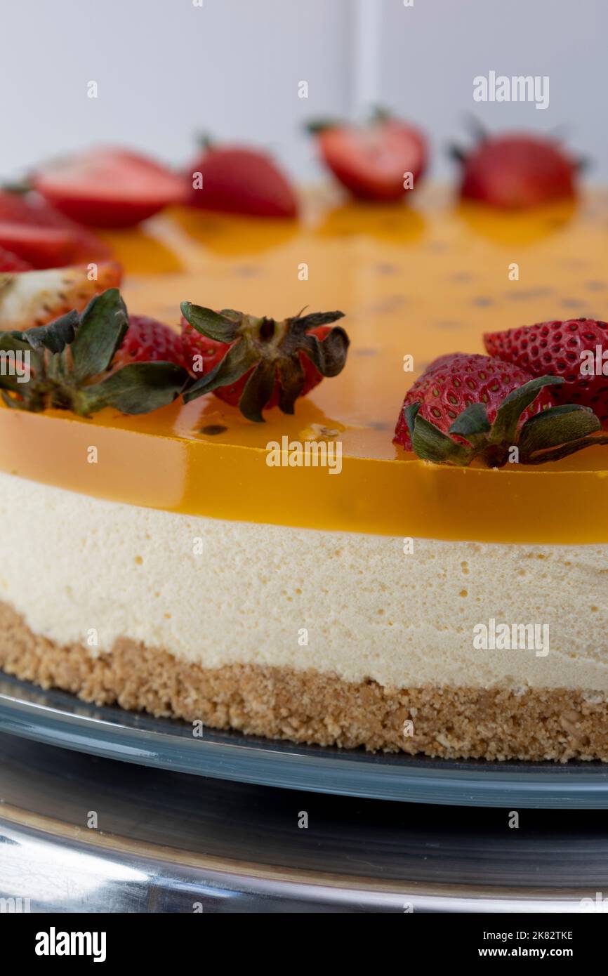 consistenza di una gustosa cheesecake alla passione, pasticceria con deliziosi dessert decorati con fragole, cibo dolce come carta da parati Foto Stock