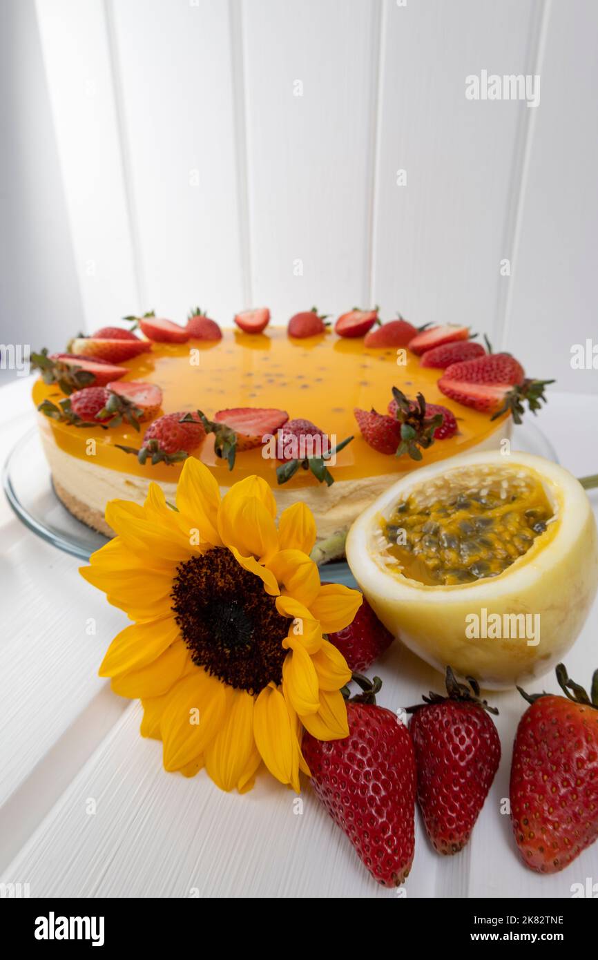 delizioso dessert dolce con crema, gelatina, fragole e frutto della passione su un tavolo, decorazione pasticceria, cibo Foto Stock