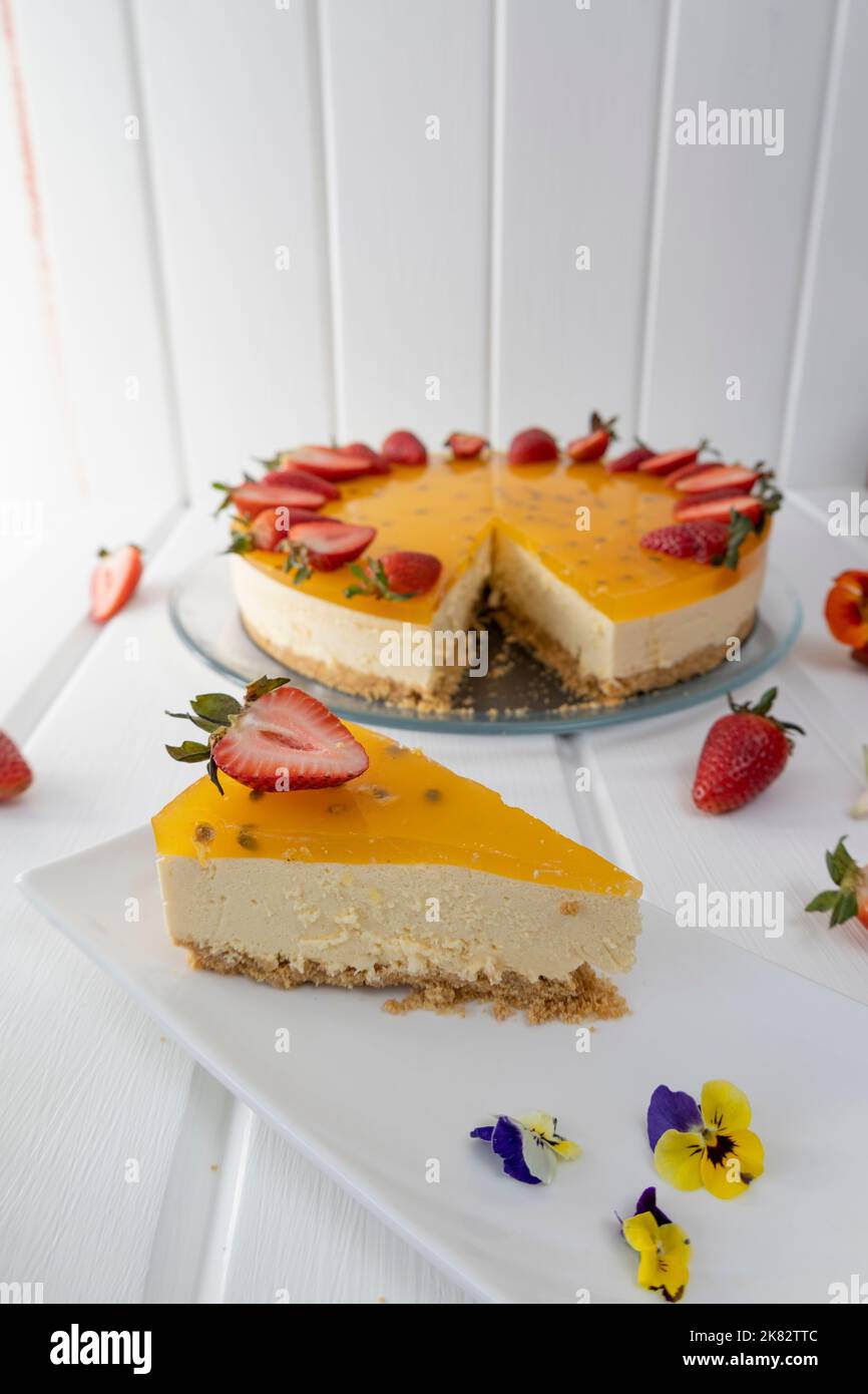 pezzo di cheesecake e torta su un tavolo, decorazione pasticceria in stile gourmet con frutto della passione, squisito cibo fresco in studio Foto Stock
