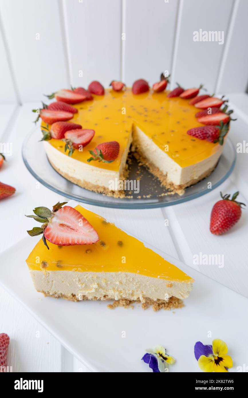 fetta di cheesecake servita su un piatto, pasticceria con frutto della passione, squisito cibo fresco in caffetteria, celebrazione con dessert Foto Stock