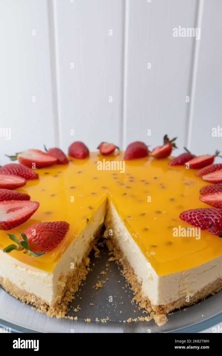 cheesecake servito su un piatto, pasticceria con frutto della passione, squisito cibo fresco in caffetteria, celebrazione con dessert dolci Foto Stock