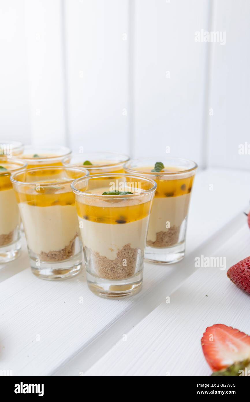deliziosa cheesecake con marmellata di frutto della passione in una tazza, spuntini gourmet in studio, deliziosi dolci, servizio catering Foto Stock