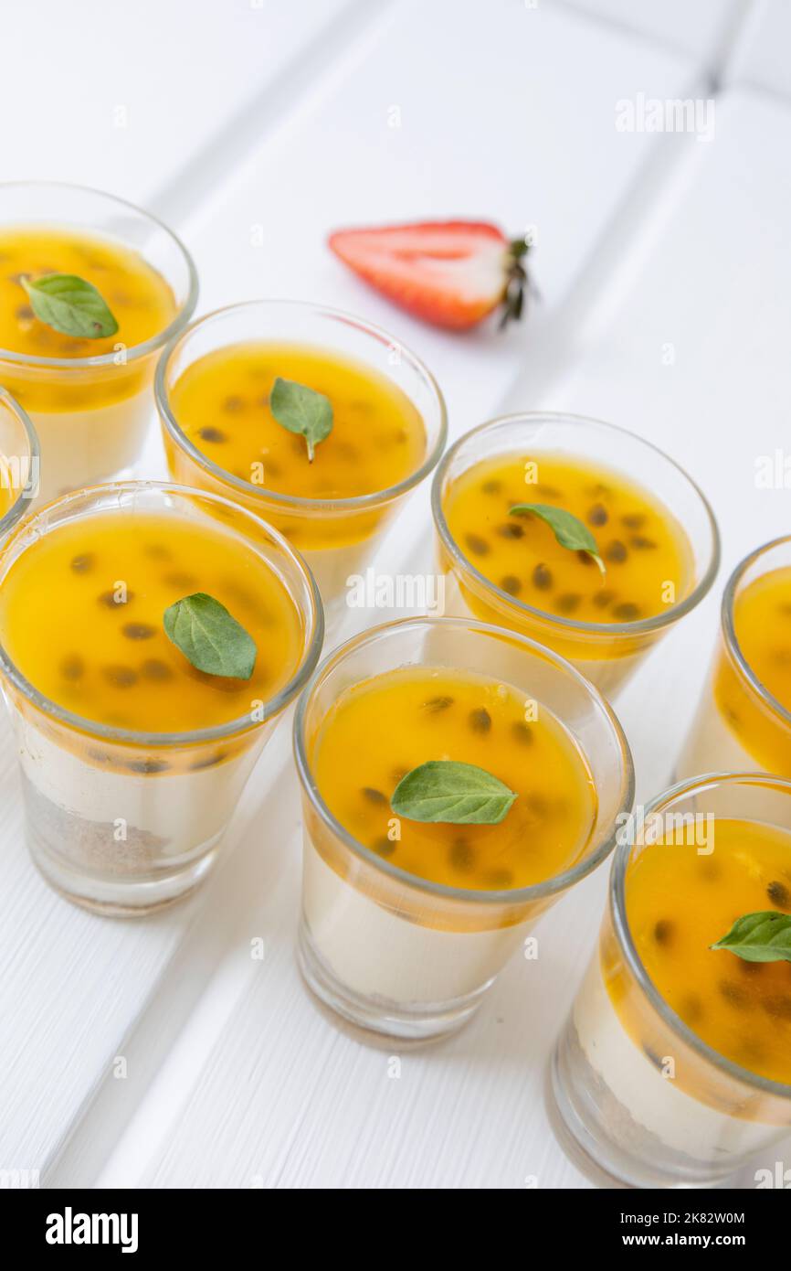 Marmellata di frutti di passione e crema in una tazza, aperitivo gourmet in studio, deliziosi dolci, servizio catering Foto Stock