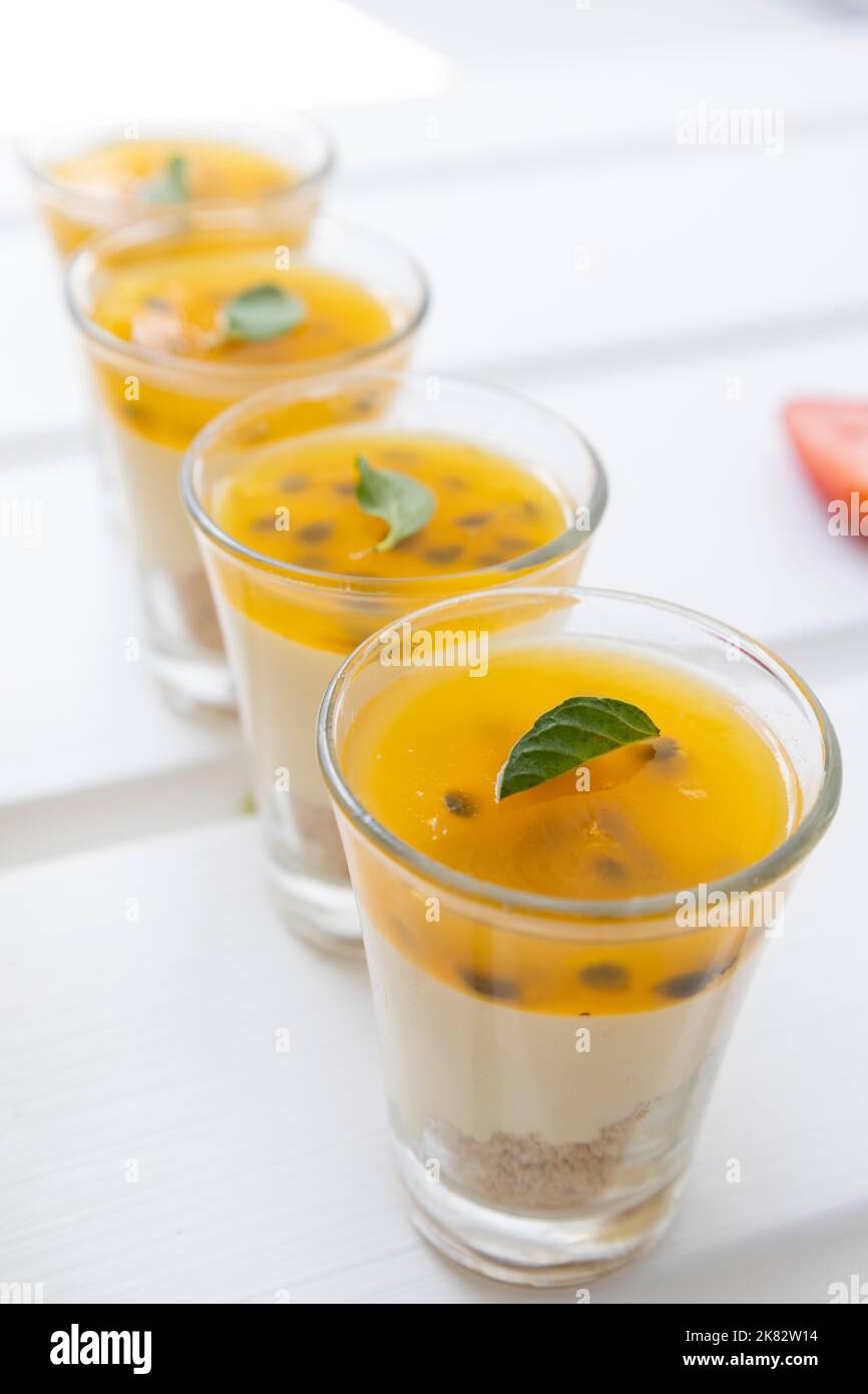 disposti in bicchieri da fila con gelatina di frutta e crema, deliziosi dolci, servizio catering con dessert Foto Stock
