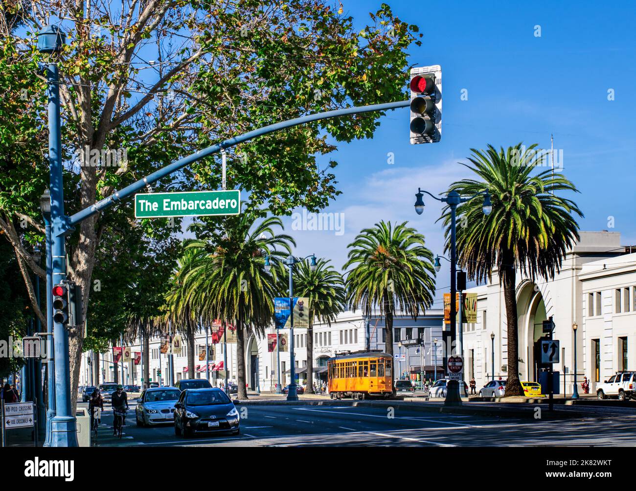 L'EMBARCADERO Palm Tree costeggiava l'Embarcadero in colore autunnale con il tipico tram di San Francisco e il cartello stradale San Francisco California USA Foto Stock