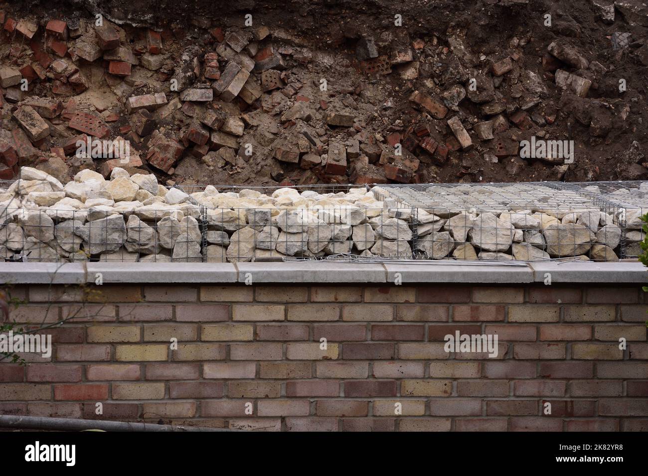 Tre tipi di muro di pietra di ritegno con mattoni in discarica e gabioni riempiti di pietra naturale e con un muro di mattoni finito Foto Stock