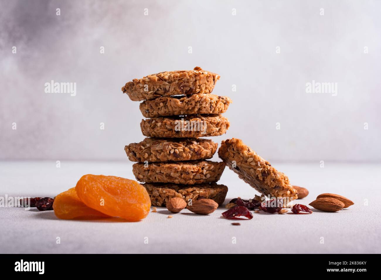 Biscotti energetici al granola o biscotti con cereali, mirtilli rossi secchi, albicocche e un mix di noci per un'alimentazione sana su fondo di cemento grigio Foto Stock