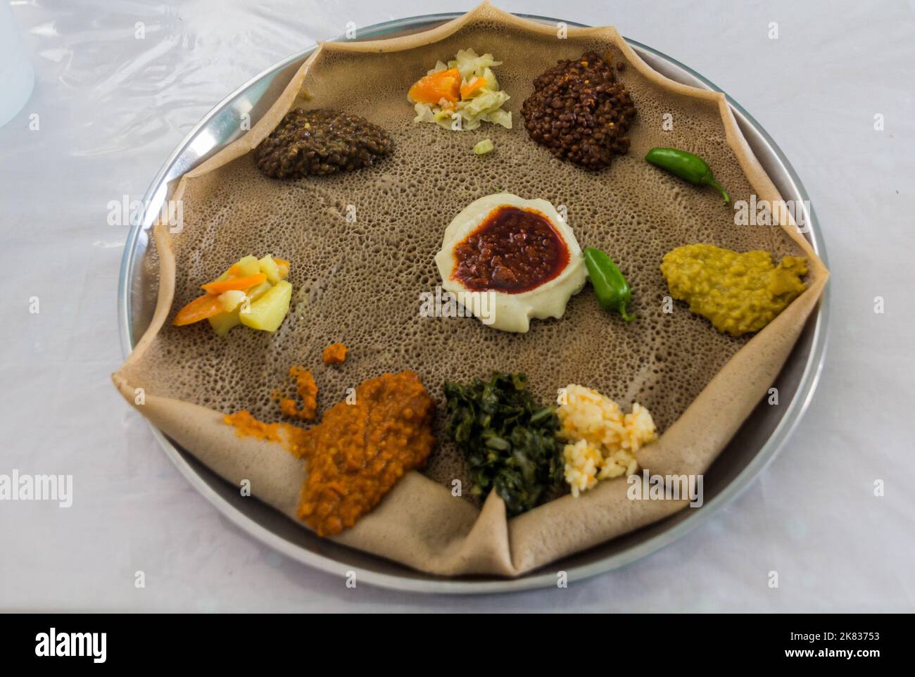 Pasto tipico in Etiopia - Beyainatu. Mearing un po' di tutto. Mix di verdure e stufati su injera flatbread. Foto Stock