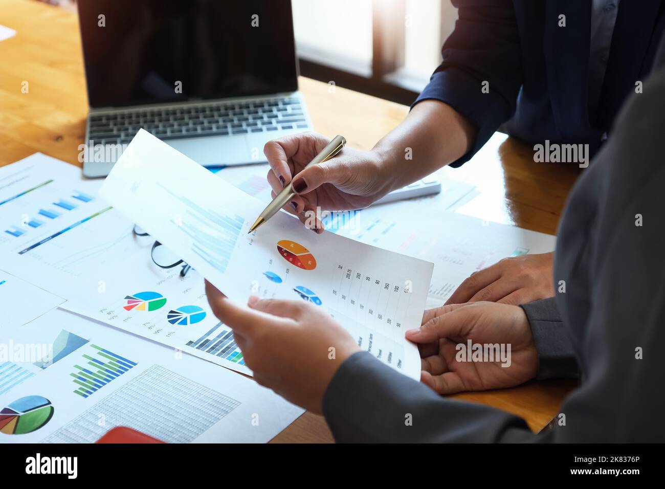 Il dipendente dell'azienda punta al documento per calcolare il budget e verificare la correttezza dell'investimento. Foto Stock