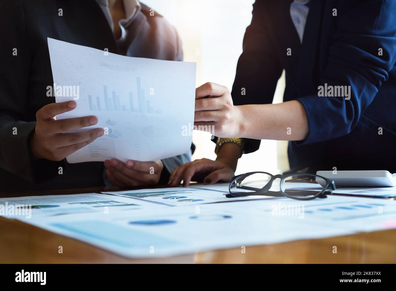 Il dipendente dell'azienda punta al documento per calcolare il budget e verificare la correttezza dell'investimento. Foto Stock