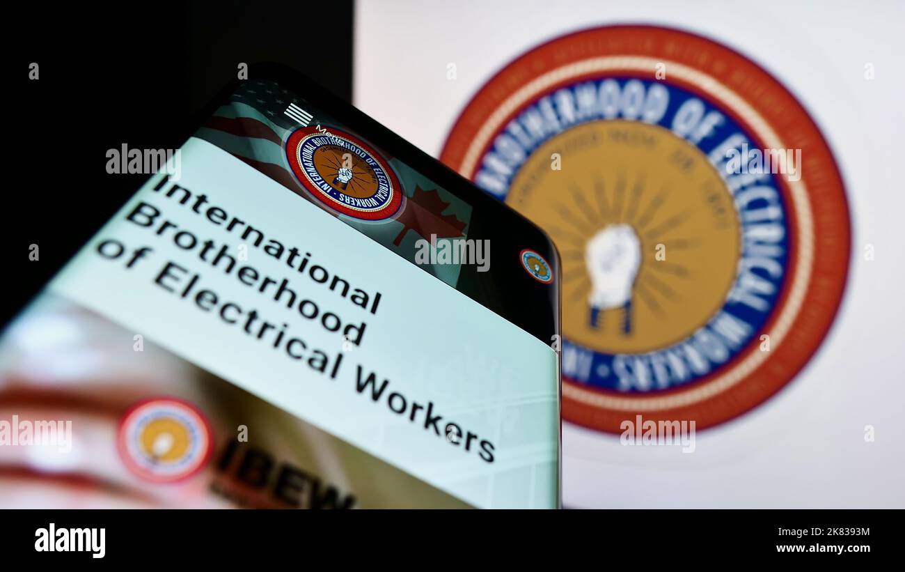 Smartphone con pagina Web del sindacato nordamericano IBEW sullo schermo davanti al logo. Messa a fuoco in alto a sinistra del display del telefono. Foto Stock