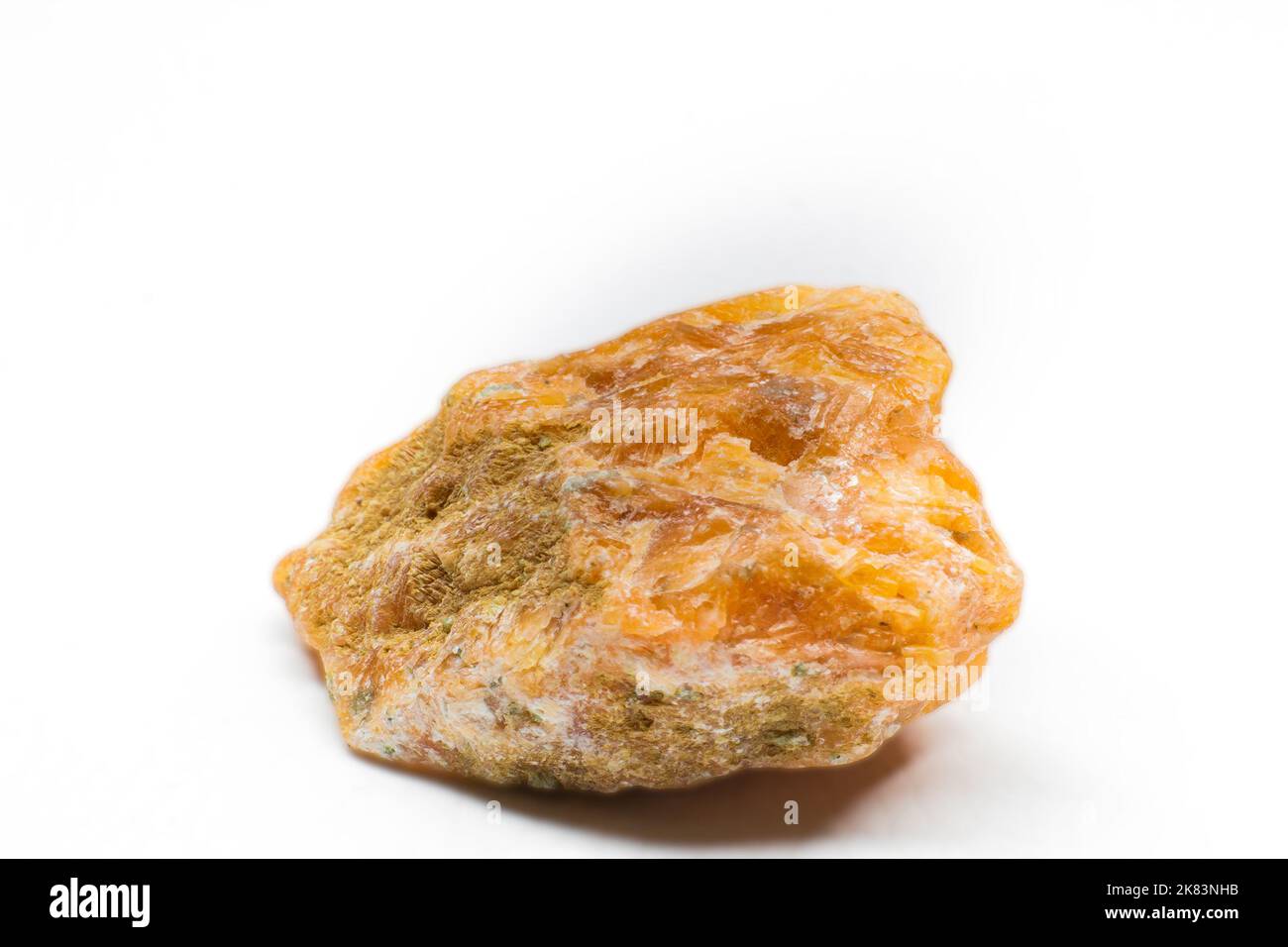 Macro di pietra di calcite grezza arancione isolata su sfondo bianco Foto Stock