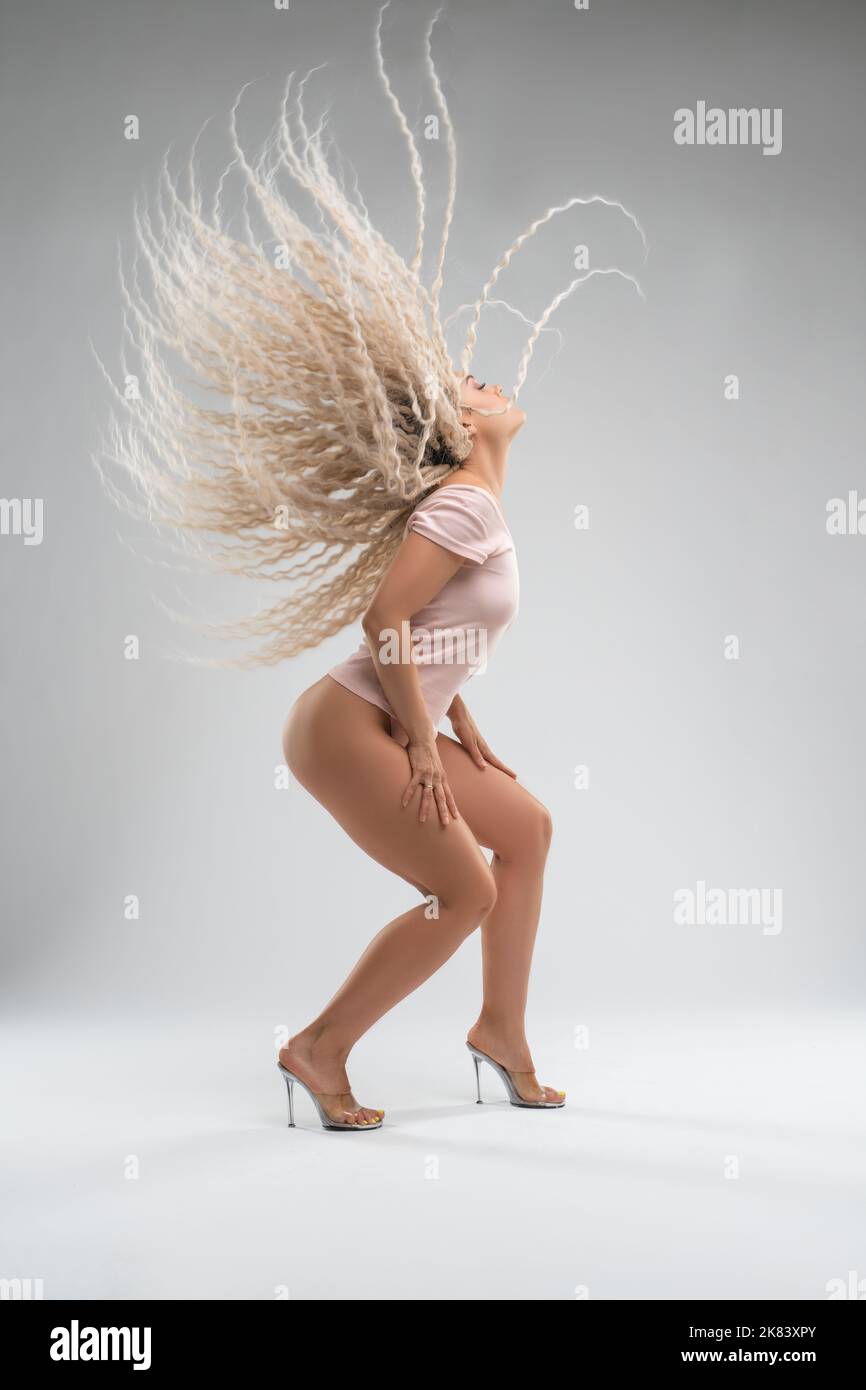 Donna sexy con lunghi capelli battenti danzare in studio Foto Stock