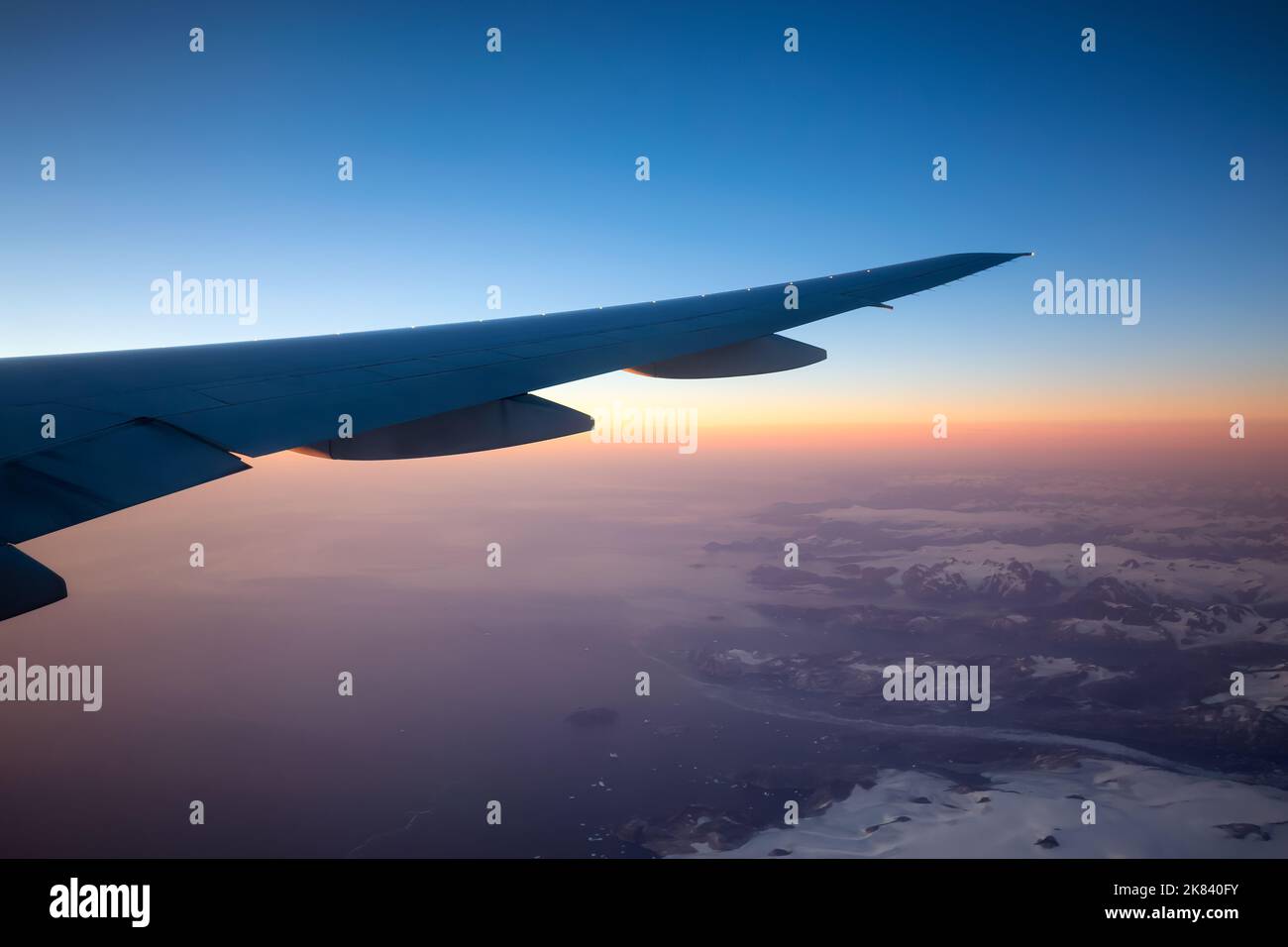 Aviazione commerciale Jetplane volare sopra il paesaggio di montagna di ghiaccio sulla costa oceanica della Groenlandia. Foto Stock