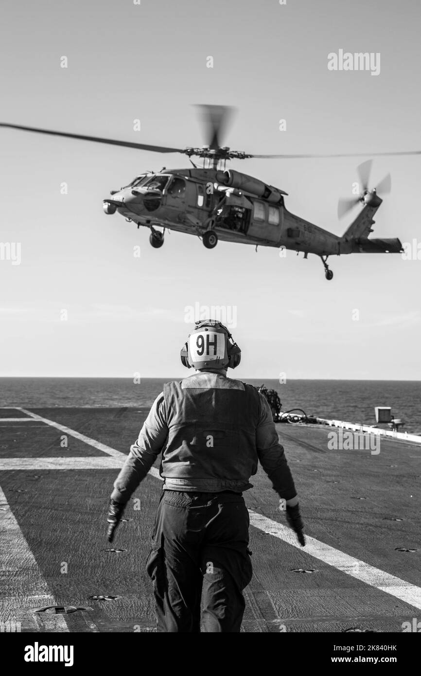 221020-N-ZG822-1639 MARE ADRIATICO (OTT 20, 2022) Un Sailor segnala un elicottero MH-60s Nighthawk, attaccato all'elicottero Sea Combat Squadron (HSC) 5, consegnando il carico dall'oliatore Kanawha di rifornimento della flotta di classe Henry J. Kaiser (T-AO 196), alla portaerei di classe Nimitz USS George H.W. Bush (CVN 77)durante l'attività di vigilanza condotta dalla NATO Nettuno Sciopero 22,2 (NIDO 22,2), nel Mare Adriatico, 20 ottobre 2022. NEST 22,2 è la naturale evoluzione della capacità della NATO di integrare le capacità di guerra marittima di alto livello di un gruppo di sciopero del vettore per sostenere la difesa dell'alleanza in Europ Foto Stock
