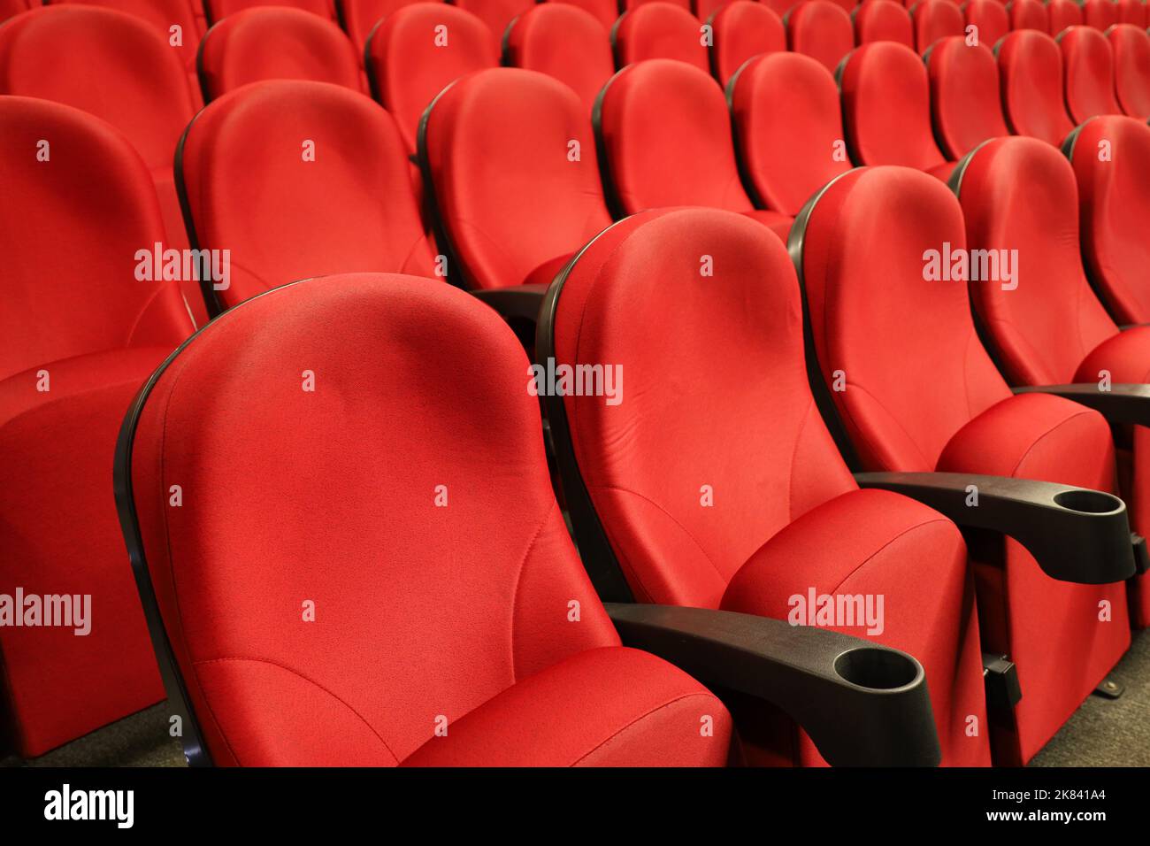 Sala cinema vuota con sedili rossi. Interni del cinema moderno, messa a fuoco selettiva Foto Stock