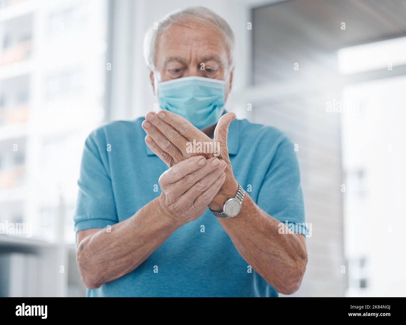 L'artrite non è divertimento. Un uomo maturo che sente le sue mani in un ospedale. Foto Stock