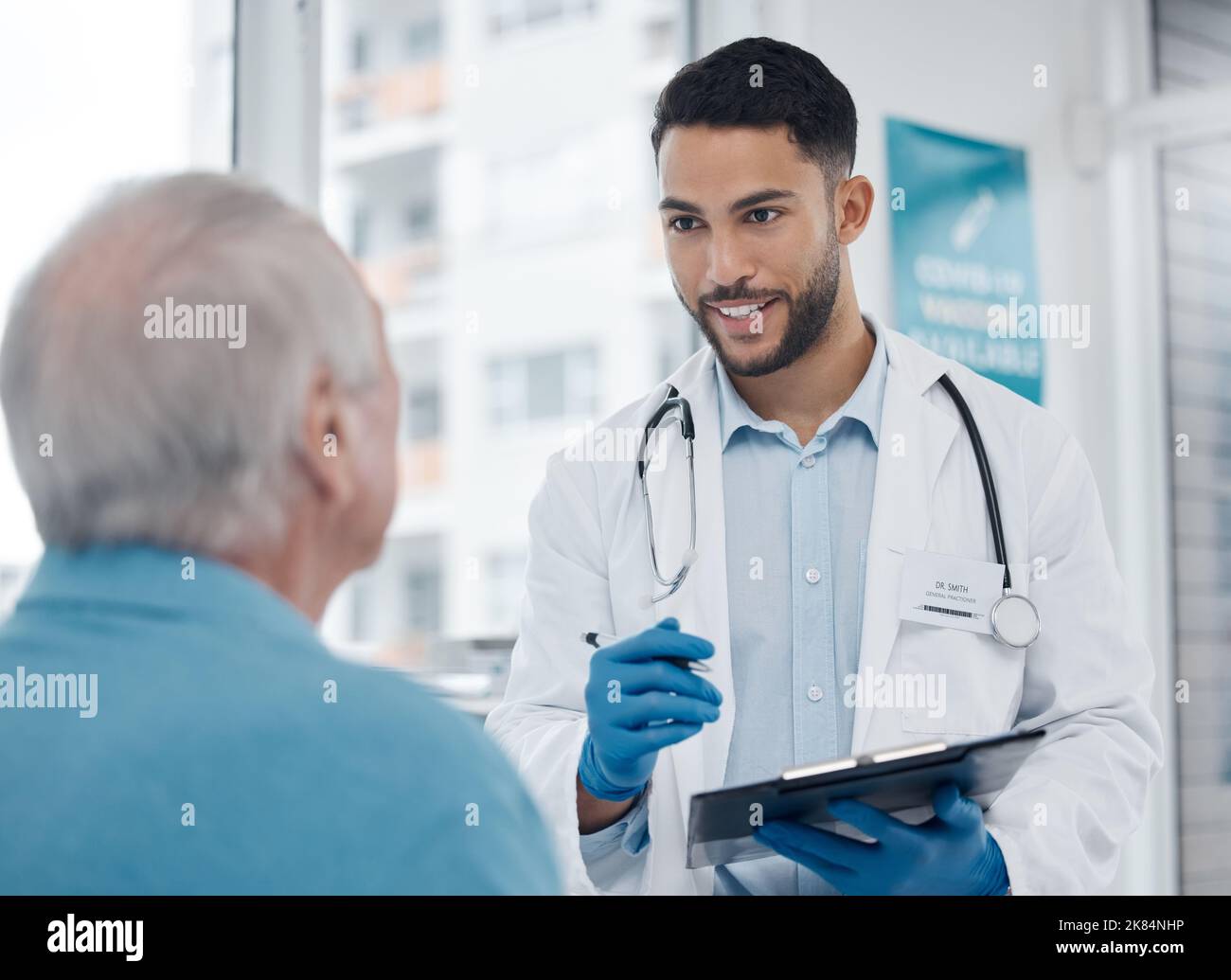 Va bene, un giovane medico che parla con un paziente in un ufficio. Foto Stock