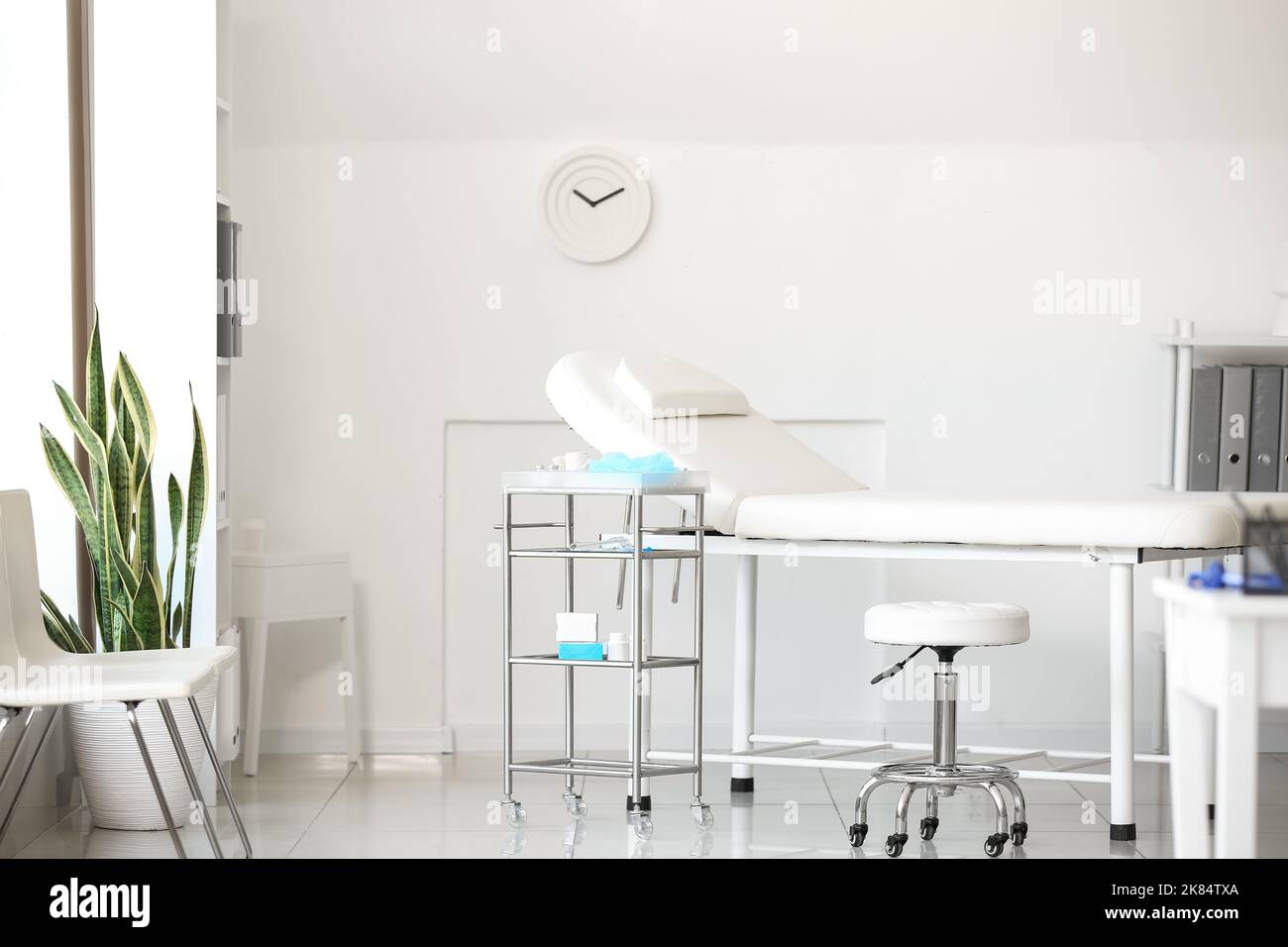 Divano e tavolo con le forniture del medico in moderno ufficio medico Foto Stock