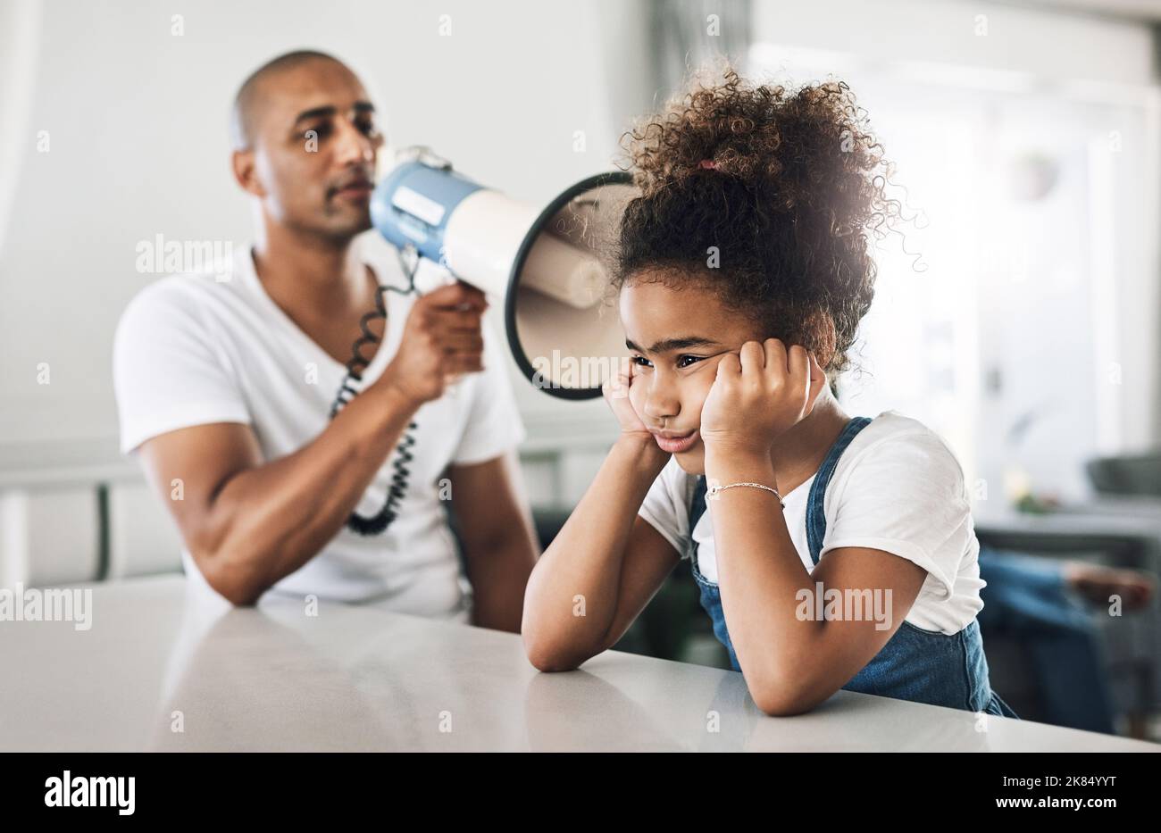 Lo sa che lo sento benissimo, un giovane padre che rimprovera un bambino a casa? Foto Stock