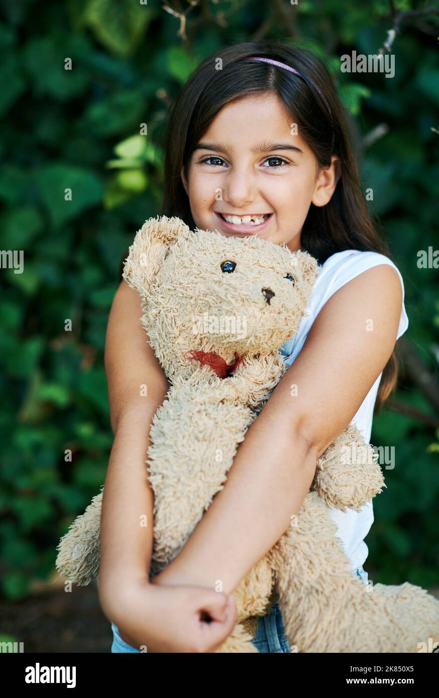 Non vado da nessuna parte senza di lui, una bambina che si alza fuori con il suo orsacchiotto. Foto Stock