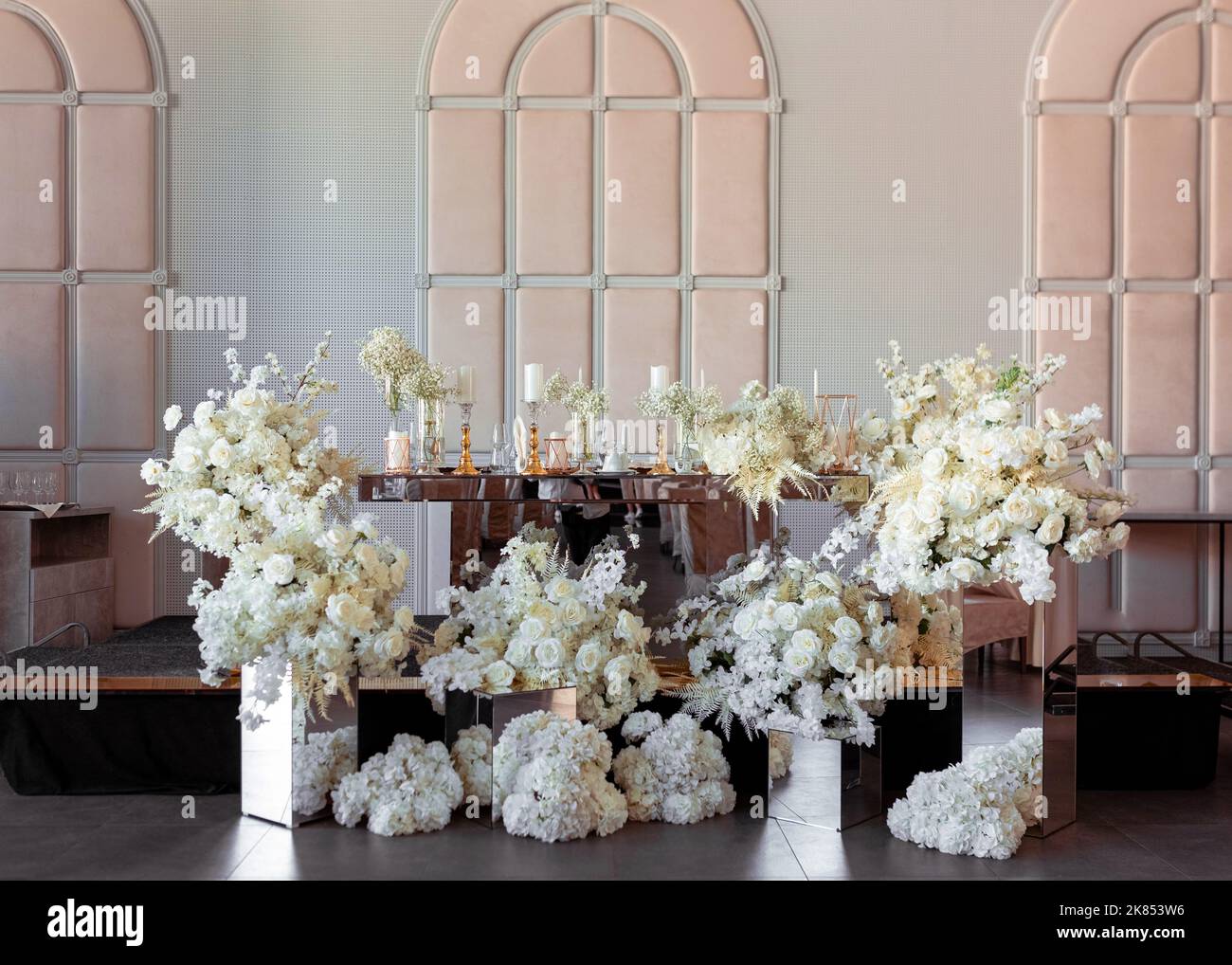 Vista frontale del tavolo da matrimonio degli sposi novelli decorato graziosamente con composizioni floreali. Decorazioni per matrimoni di lusso in tonalità costose Foto Stock